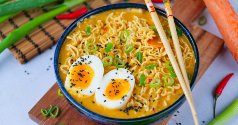 Soupe de curry, nouilles, légumes et oeufs mollets